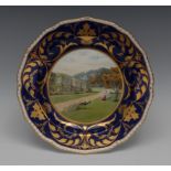 A Royal Crown Derby shaped circular plate, painted by Cuthbert Gresley, signed, with Haddon Hall,