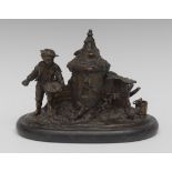 A 19th century French dark patinated bronze novelty inkstand, cast as a young boy in a farmyard,