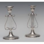 A pair of Edwardian silver lyre shaped table candlesticks, of George III design,