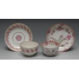 A Worcester tea bowl and saucer, decorated with pink and purple stylised flowers and foliage,