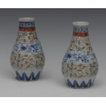 A pair of Chinese ovoid vases, banded with stylised foliage, in green, cobalt blue and iron red,