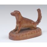 A Brampton brown salt glazed stoneware model of a seated dog, tail upright,