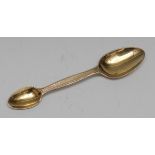 A Victorian silver-gilt double-ended medicine spoon, in differing measures, engine turned haft,