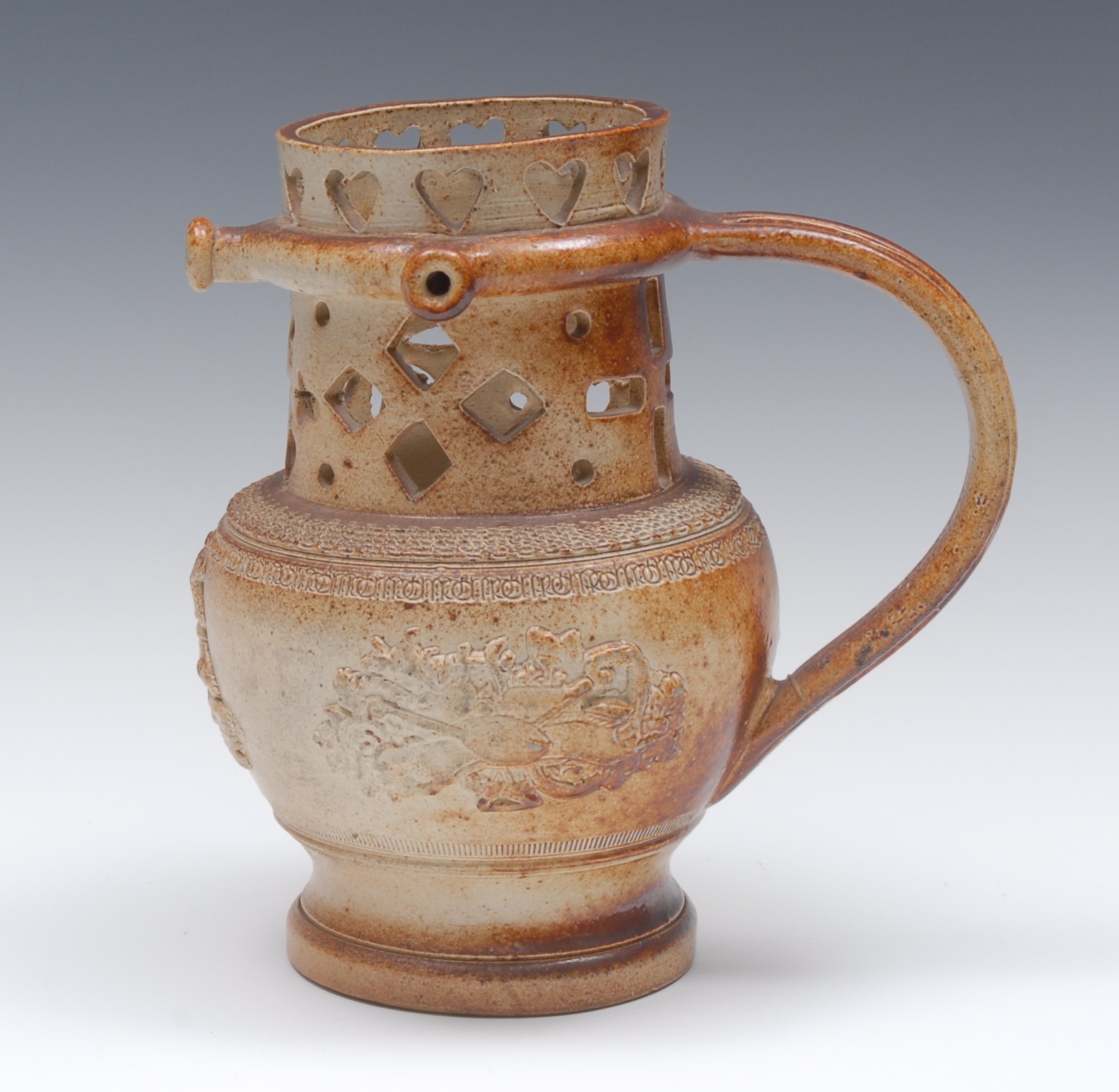 A 19th century brown salt glazed stoneware puzzle jug, pierced with hearts and geometric motifs,
