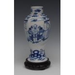 A Chinese slender baluster vase, decorated in underglaze blue with a shop keeper,