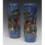 A pair of Chinese pottery cylindrical rustic vases, moulded in relief with figures,