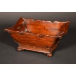 A George III style mahogany boat shaped trough or coaster, serpentine C-scroll border, fluted apron,