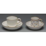 A Sevres coffee cup and saucer, decorated overall with blue and gilt scattered sprigs,