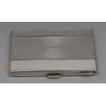 An Art Deco silver and enamel rectangular cigarette case, hinged cover, engine turned,