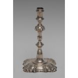 A George II silver cast taper stick, reel shaped sconce, knopped stem,