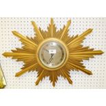 A giltwood starburst wallclock by Elliot retailed through Pearce & Sons, Ltd., Leicester.
