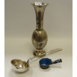 An Indian silver coloured vase; a silver coloured ladle;