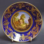 A Derby circular saucer dish, the fielded painted with cottage in a landscape, gilt line border,