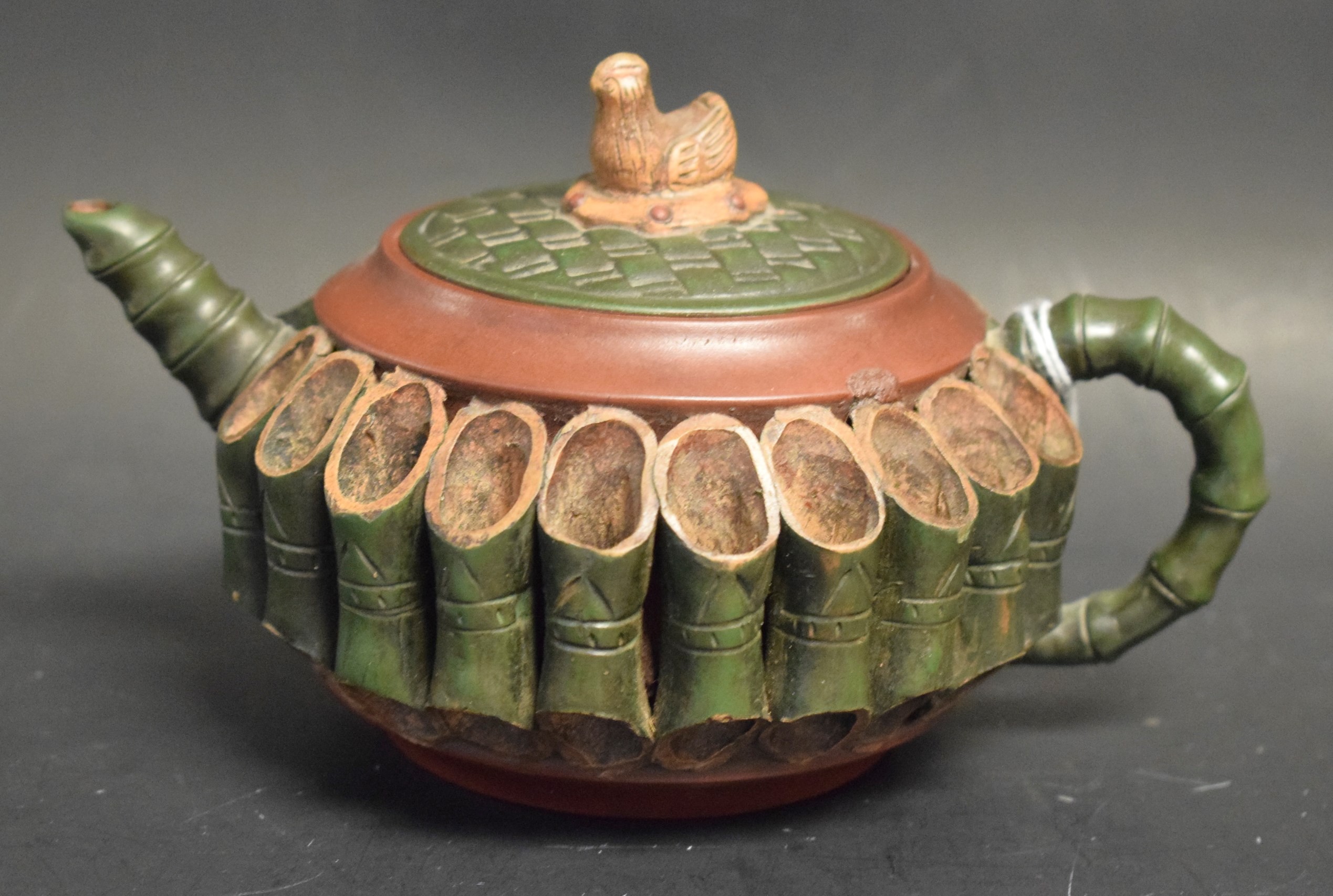 A Chinese Yixing terracotta teapot and cover, applied with sections of bamboo,
