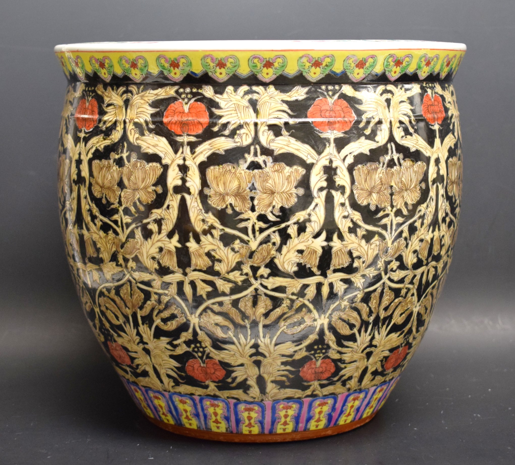 A Chinese ovoid jardiniere, painted in the famille noir palette with a ground of stylised flowers,