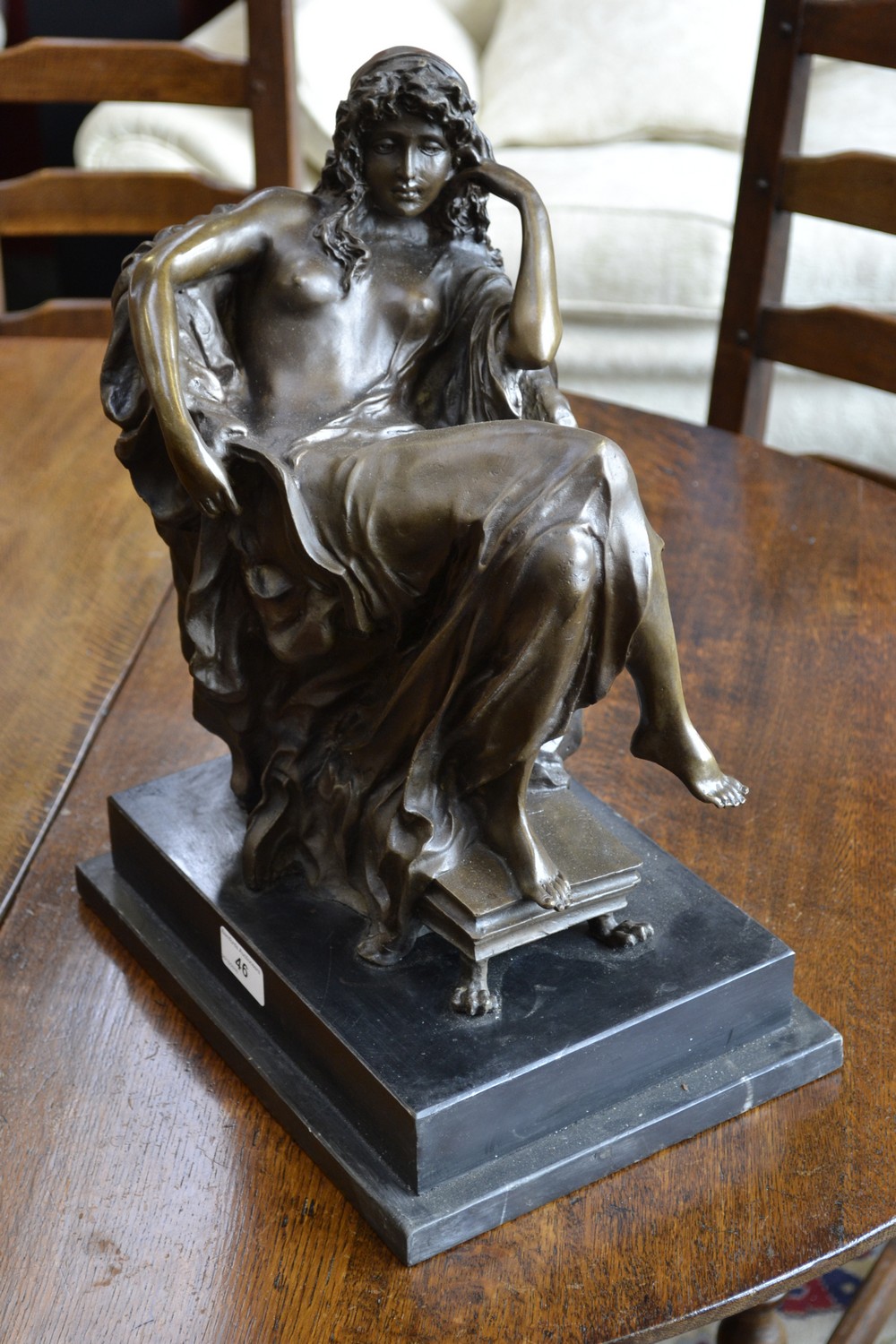 A bronze study of a seated nude on marble plinth.