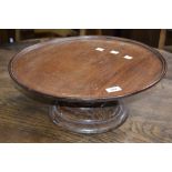 A 19th century mahogany lazy Susan, circular top with shallow border, turned column and base,