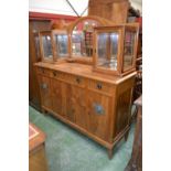 A teak mirror back sideboard, arched mirror flanked by display cabinets to top,