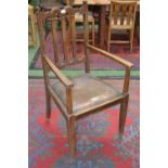 An Arts and Crafts oak carver chair, shaped top rail, drop in seat, tapering square supports.