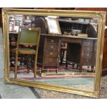 A large contemporary gilt framed wall mirror.