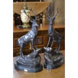 A pair of bronze stags on marble plinths