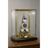 A cased skeleton clock, fusee movement, moon phase, date and day dials, enamelled chapter ring,