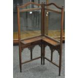 A late Victorian bi-fold firescreen, turned finials, arched glazed panels over folding shelves,