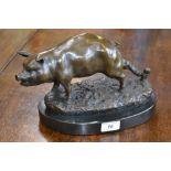 A bronze figure of a pig mounted on a marble plinth.