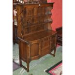 An oak dresser, stepped cornice, shaped frieze, two shelves to top,