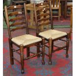 A pair of country house ladderback dining chairs with rush seats.