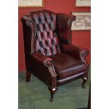 An executive office ox blood leather button upholstered wingback armchair.