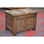 An oak blanket box of small proportions, two panelled hinged lid, conforming front. 38cm high x 55.