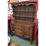 An oak dresser, stepped cornice, shaped frieze, two shelves to top,