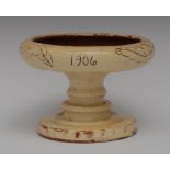 A Torquay Ware pedestal dish, incised with scrolling leaves adn dated 1906, 19cm diam,