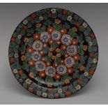 A Swiss Thoune pottery circular dish, enamelled overall with flowers and foliage,