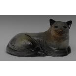 An Art Pottery model of a resting cat, incised features with knowing grin,