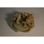 A Chinese jade roundel, carved as an ensnaring mythical beast, 5.
