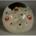 A domed millefiori paperweight, decorated with coloured canes and opaque spirals,