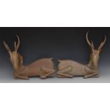 A pair of pine and antler hunting lodge wall plaques, carved as recumbent deers, 43cm wide,