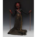 An Indonesian carved and painted wayang golek puppet, as a red-faced demonic figure,