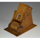 An early 20th century oak rotating perpetual desk calendar, gravity mechanism,