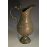 A Middle Eastern Islamic tinned copper baluster ewer, chased with Arabic script,