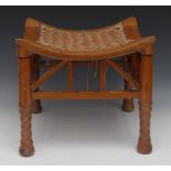 An Egyptian Revival mahogany Thebes stool, in the manner of Liberty, woven shaped seat,