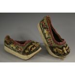 A pair of Chinese silk lady's shoes, embroidered with flowers and further foliage,