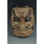 A Japanese carved and painted noh mask, whiskered face with grotesque features,