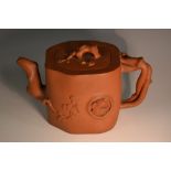 A Chinese Yixing terracotta tea pot, moulded and applied with prunus root finial and bamboo handle,