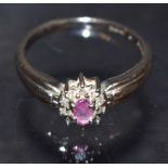 A pink sapphire and diamond cluster ring; central oval pink sapphire,