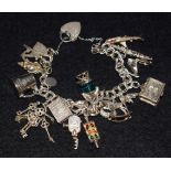 A silver charm bracelet, suspending fifteen assorted charms inc Shark, Tankard, Keys, Cine Camera,