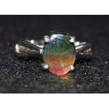 A simulated black opal doublet ring, oval simulated black opal panel, flashing green, red,