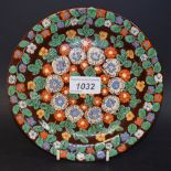 A Swiss Thoune pottery circular dish, enamelled overall with flowers and foliage,